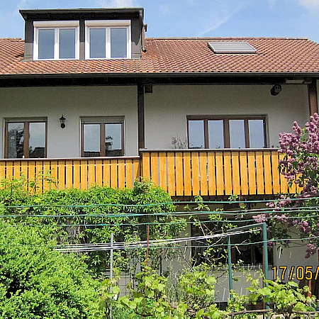 Ferienhaus Renate Außenansicht, Dach mit Gaube und gelben Balkonbrettern