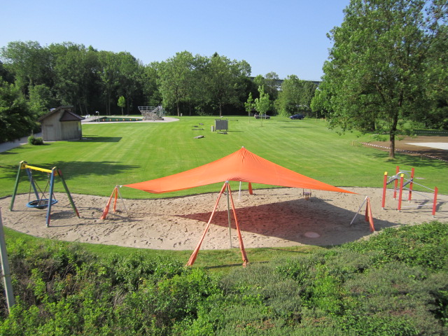 Sandplatz für Kinder mit orangem Sonnensegel
