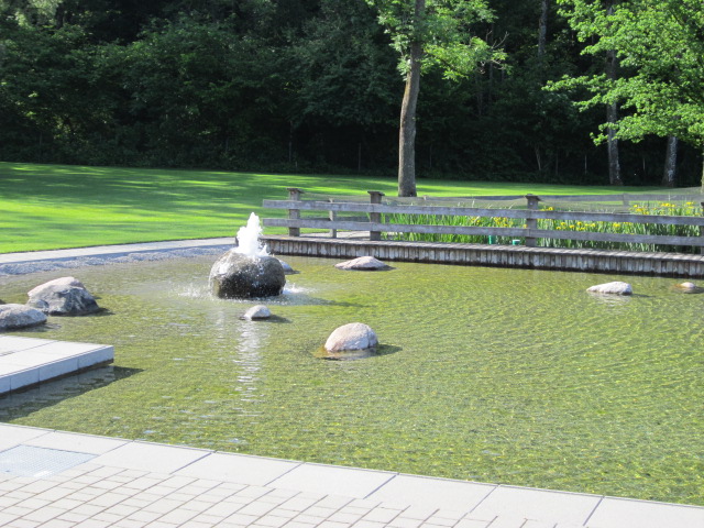 Springbrunnen aus einem großen Stein im Wasserbecken des Naturbades